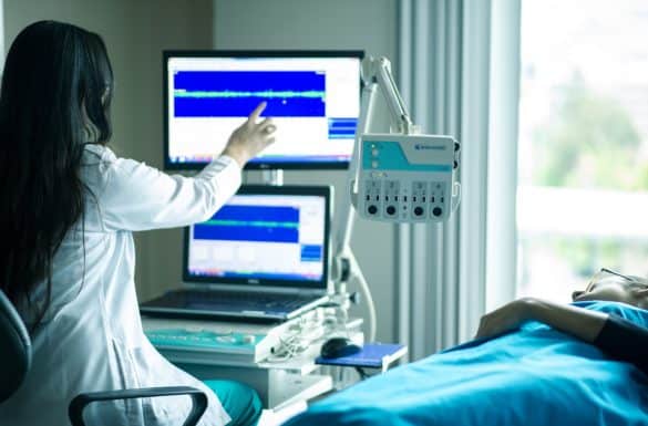 Doctor reviewing medical equipment with patient next to her